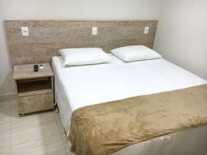 1 dormitorio con cama grande y cabecero de madera en Pousada Della Nonna en Presidente Prudente