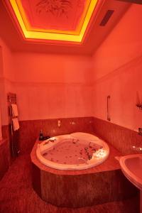 La salle de bains est pourvue d'une grande baignoire et d'un lavabo. dans l'établissement Exis Hotel, à Athènes
