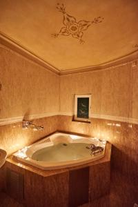 La salle de bains est pourvue d'une baignoire et d'une peinture au plafond. dans l'établissement Exis Hotel, à Athènes