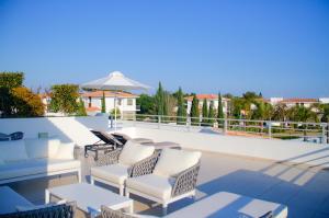 a group of chairs and tables on a swimming pool at Atlantis Gardens in Mazotos