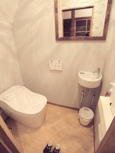 ein Badezimmer mit einem WC, einem Waschbecken und einem Spiegel in der Unterkunft KINOSAKI KNOT in Toyooka