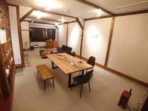 Pokój z drewnianym stołem i krzesłami w obiekcie KINOSAKI KNOT w mieście Toyooka