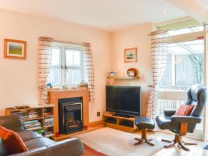 a living room with a fireplace and a television at River Cottage Hot tub spa in Drumnadrochit