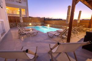 patio z krzesłami i basenem w obiekcie Prinos Oasis Twin Villas II w mieście Prínos