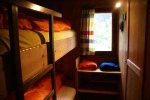 a small room with bunk beds and a window at La Crappa in Andeer