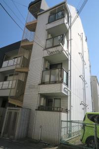 un immeuble d'appartements avec balcon sur le côté. dans l'établissement SIMPLY WHiTE GUEST ROOM302, à Osaka