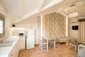 una cucina e una sala da pranzo con tavolo e sedie di Paradise Vezal a Laganas