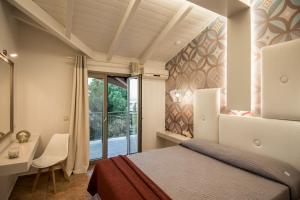 a bedroom with a bed and a desk and a window at Paradise Vezal in Laganas