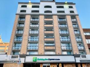 a tall building with a sign in front of it at Holiday Inn Express and Suites Calgary, an IHG Hotel in Calgary