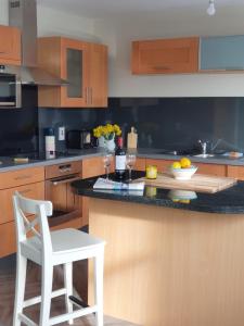 a kitchen with a white chair and a counter with wine glasses at The Plaza Suites High St Bangor in Bangor