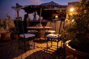 a table and chairs on a patio at night at Dar Settash in Fez