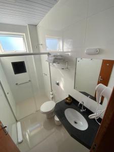 a white bathroom with a sink and a toilet at JP Palace Hotel in Franca