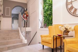 a living room with yellow chairs and a table at Dedo Boutique Hotel in Florence