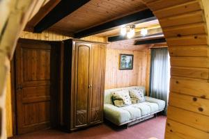 a living room with a couch and a wooden wall at Бойківчанка in Yaremche