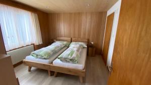 a bedroom with a wooden bed with two pillows at Chalet Acheregg in Wengen