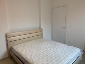 Dormitorio blanco con cama y armario en Le case di Chiara, en San Pietro in Casale
