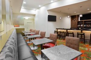 a restaurant with tables and chairs and a bar at Staybridge Suites - Miami International Airport by IHG in Miami