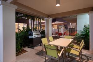 a patio with a table and chairs and a grill at Staybridge Suites - Miami International Airport by IHG in Miami