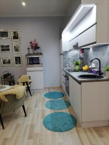 een keuken met een wastafel en twee tapijten op de vloer bij PANNONIA Budapest Center DELUXE in Boedapest