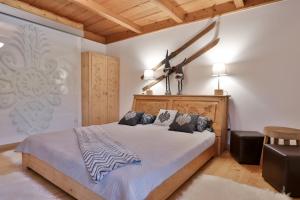 une chambre avec un grand lit avec une tête de lit en bois dans l'établissement Willa na Równi, à Zakopane