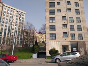 dwa samochody zaparkowane przed wysokim budynkiem w obiekcie Apartamento completo con parking privado y WiFi en San Roque w mieście Vigo