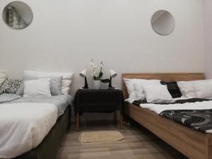 a bedroom with two beds and a table with a chair at PANNONIA Budapest Center DELUXE in Budapest