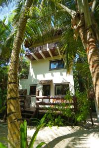 una casa en la playa con palmeras delante en Playa Selva, en Tulum