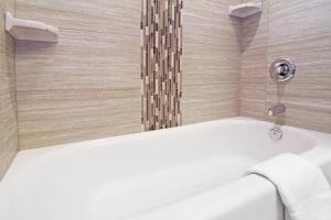 a bathroom with a bath tub with a shower at Holiday Inn Express and Suites Calgary University, an IHG Hotel in Calgary