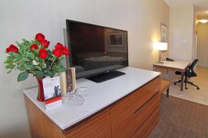 Cette chambre dispose d'une télévision et d'un vase de roses rouges. dans l'établissement Holiday Inn Express and Suites Calgary University, an IHG Hotel, à Calgary