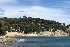 a view of a beach with trees and water at Les terrasses du Liouquet T2, piscine , parking , mer à 150 m in La Ciotat
