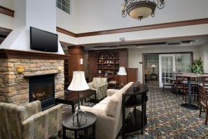 a living room with a fireplace and a tv at Staybridge Suites North Brunswick, an IHG Hotel in North Brunswick
