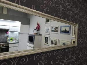 a mirror hanging on a wall with a kitchen at PANNONIA Budapest Center DELUXE in Budapest