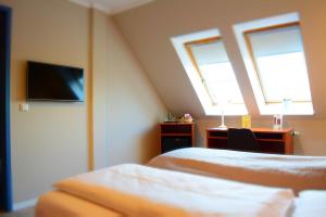 a bedroom with two beds and a desk and a tv at Klausdorfer Hof in Schwentinental