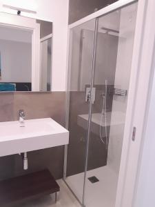 a bathroom with a glass shower and a sink at Wave Tower Residence in Lignano Sabbiadoro +40 photos