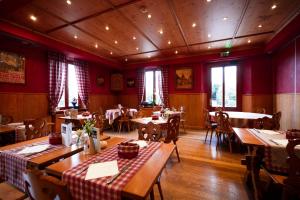 a restaurant with tables and chairs and red walls at Le Rosenmeer - Hotel Restaurant, au coeur de la route des vins d'Alsace in Rosheim