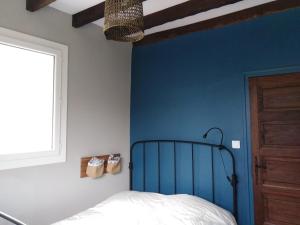 a bedroom with a blue accent wall and a bed at GITE IBARLA BORDA in Bidarray