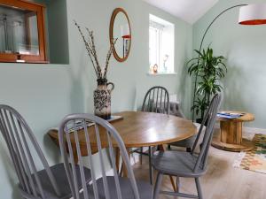 a dining room with a wooden table and chairs at Robin's Nest Cottage in Great Driffield