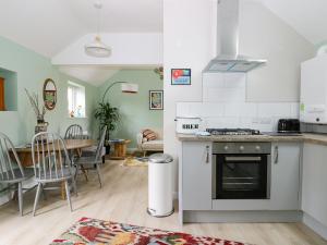a kitchen with a stove and a dining room at Robin's Nest Cottage in Great Driffield