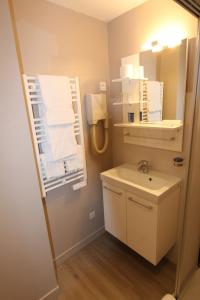 a small bathroom with a sink and a mirror at Hotel des Abers in Saint Malo