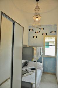 a bedroom with a bunk bed and a mirror at dimoradamare in Villaggio Azzurro