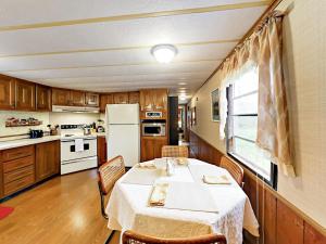 a kitchen with a table and chairs and a refrigerator at Serenity Views Bungalow - Close to City and Parkway! in Weaverville