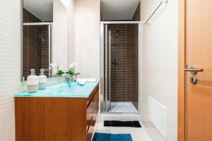 een badkamer met een blauwe wastafel en een douche bij OCEANVIEW Luxury Amazing Views and Pool in Olhão +19 foto's