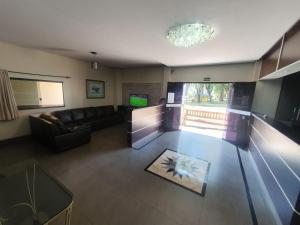a living room with a couch and a television at Hotel Meyer in Francisco Beltrão