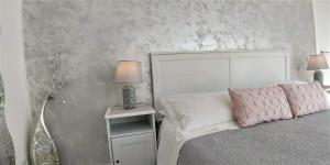 a bedroom with a bed and a night stand with a lamp at La Petite Maison in Taormina