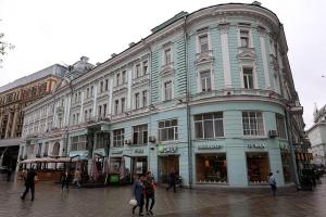 a large building on a street with people walking in front of it at D-Hotel Tverskaya in Moscow