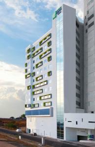 Un alto edificio bianco con un cartello sopra di Holiday Inn Express & Suites Puebla Angelopolis, an IHG Hotel a Puebla