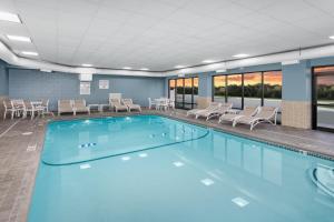 a large swimming pool with chairs and tables in a building at Holiday Inn Express South Portland, an IHG Hotel in South Portland