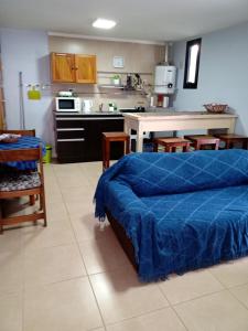 1 dormitorio con 1 cama azul y cocina en Departamento Rocío con cochera, La Perla, Mar del Plata en Mar del Plata
