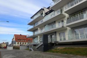 ein Apartmenthaus mit Balkon an der Seite in der Unterkunft Ekskluzywny apartamet Pan Tadeusz III z widokiem na jezioro in Giżycko