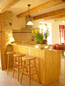 uma cozinha com um balcão com bancos e um lavatório em Les Chanterelles Montmin em Plan Motmin